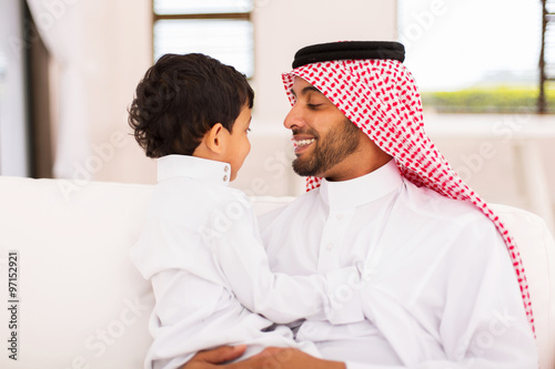 arabian father and son sitting at home