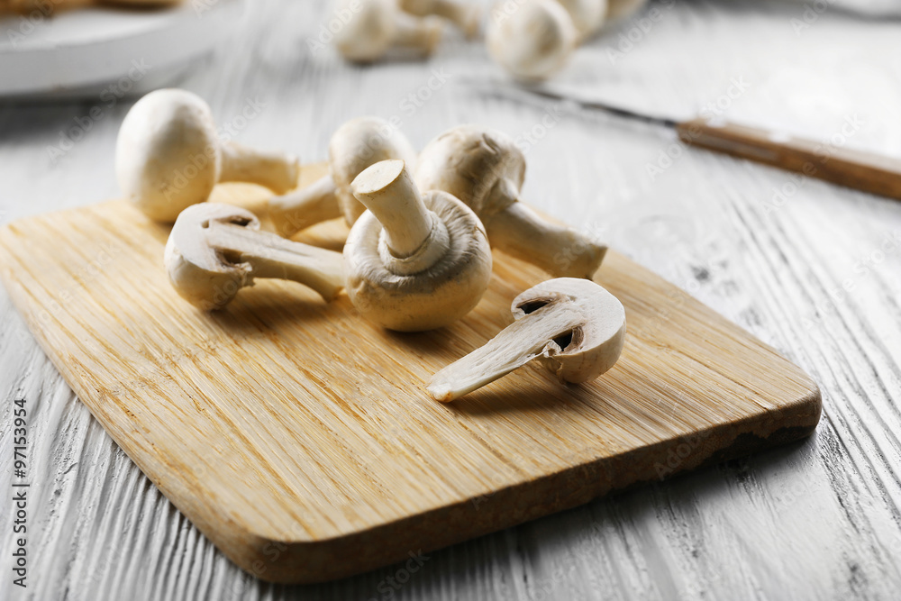 Champignon mushrooms, a knife on wooden background Champignon mushrooms, a knife on wooden background