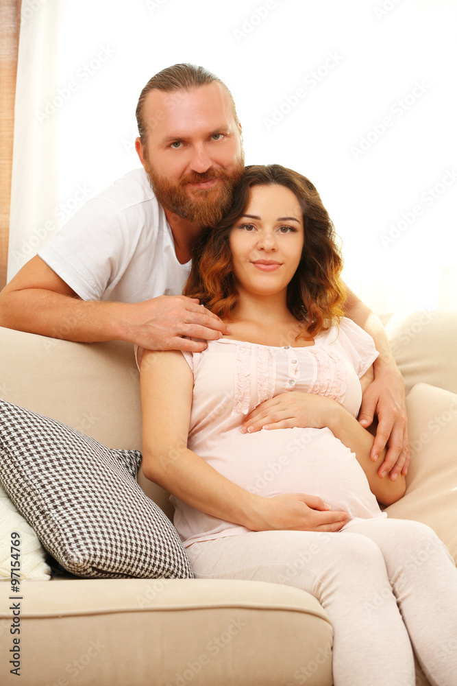 Handsome man takes care about his lovely pregnant woman