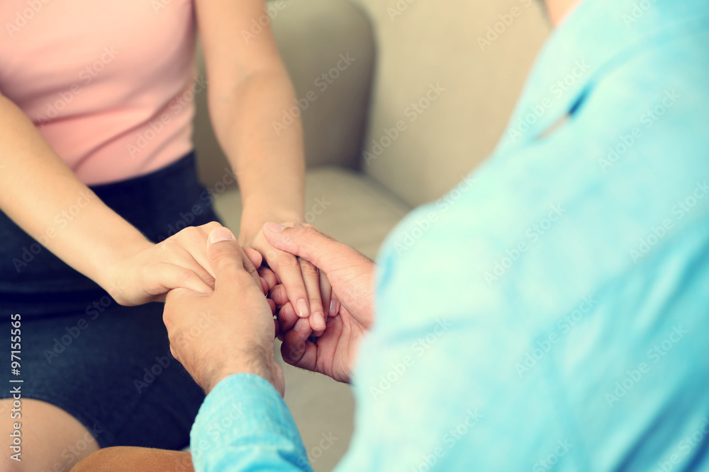 Concept of support - man and woman holding hands in the room Concept of support - man and woman holding hands in the room