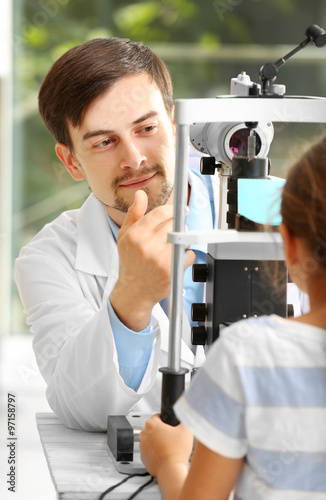 Adult male doctor examing small girl patient