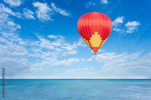 Colorful hot air balloon over blue sea