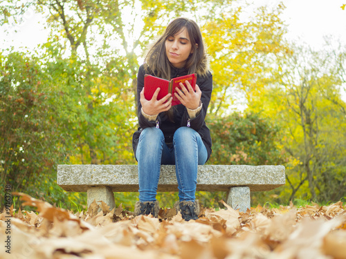 mujer leyendo en un parque en otoño