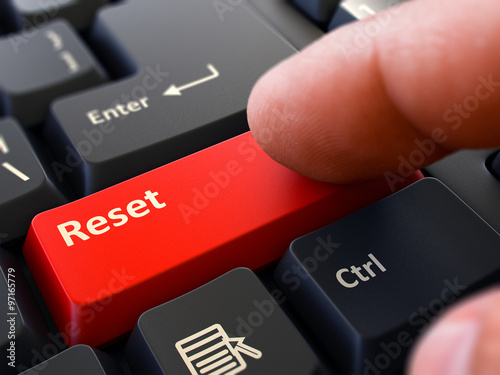 Finger Presses Red Keyboard Button Reset.