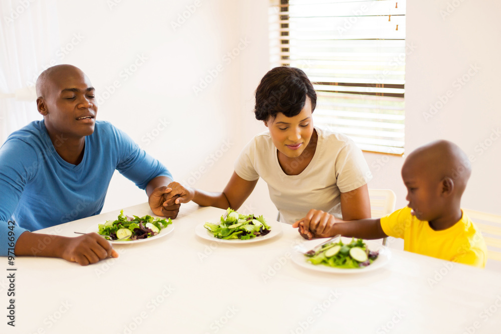 young african family praying before having meal young african family praying before having meal