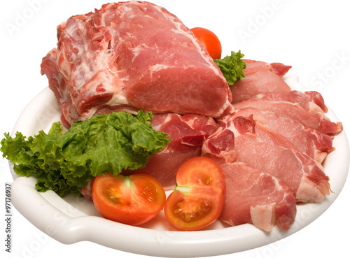 white plate containing raw meat with white streaks of fat, lettuce leaves and cherry tomatoes on the side
