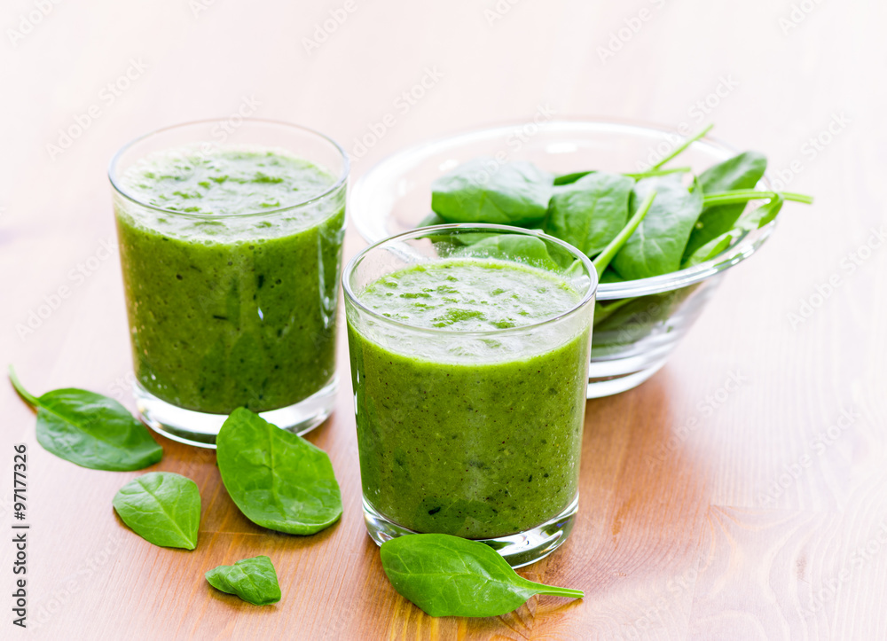 Two glass of green smoothie with spinach on wooden surface Two glass of green smoothie with spinach on wooden surface