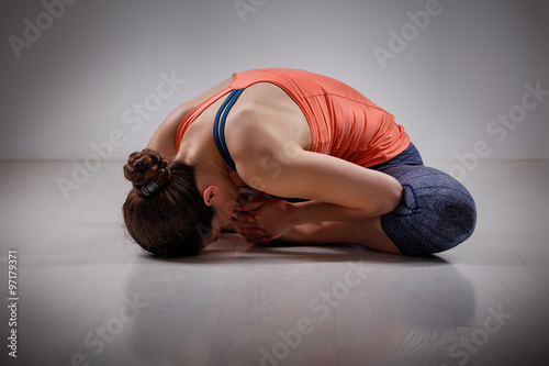 Woman practices yoga asana Baddha konasana photo