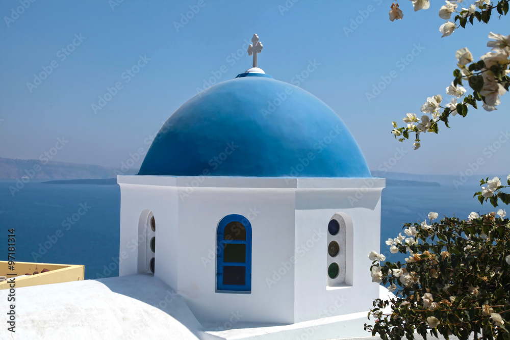 White orthodox church with blue dome, Santorini island, Greece.