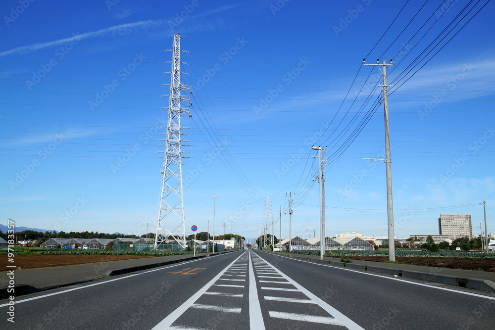 steel tower and straight road in the blue sky