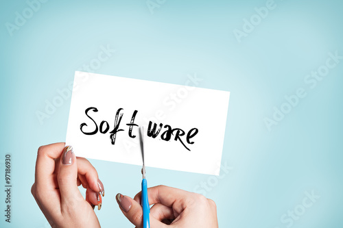 Woman hands cutting card with the word software