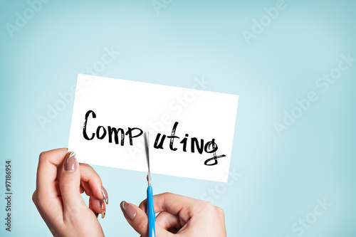 Woman hands cutting card with the word computing