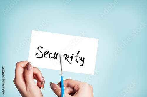 Woman hands cutting card with the word security