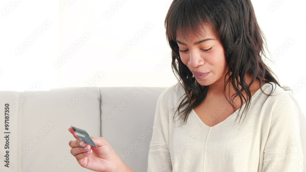 Smiling woman with a credit card and a laptop on a sofa Smiling woman with a credit card and a laptop on a sofa