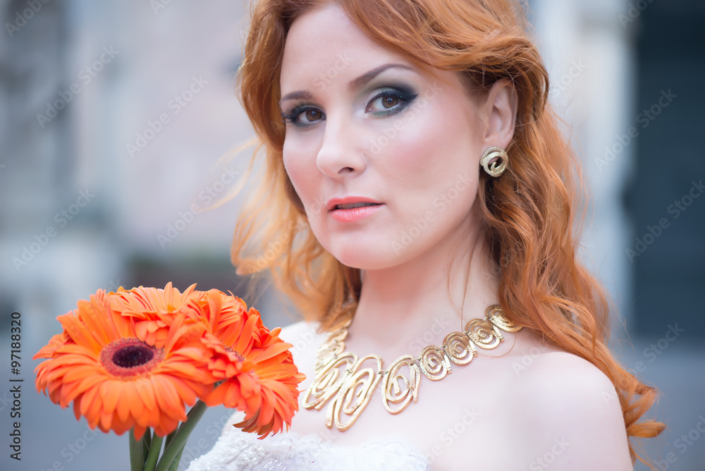Naklejka premium A young woman in a wedding dress with bright bouquet of gerberas