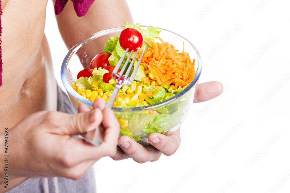Close-up of a fitness man holding a bowl of salad, isolated on w Close-up of a fitness man holding a bowl of salad, isolated on w