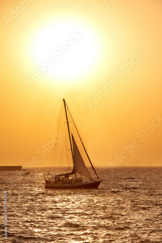 Sail boat against sea sunset