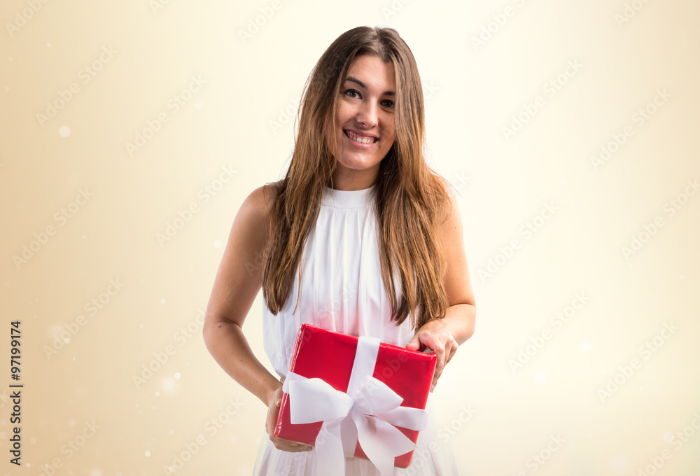 Pretty girl in white dress holding a gift Pretty girl in white dress holding a gift