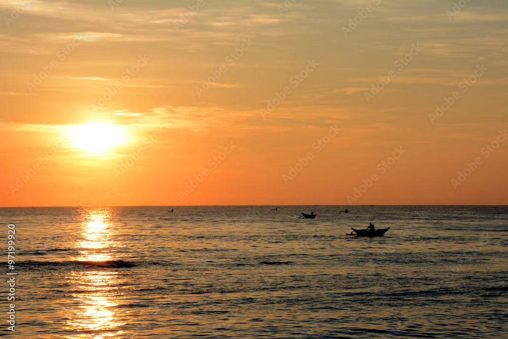 Wild beautiful beaches of Sri Lanka. Golden tropical sunset. Silhouette of fishermen on the horizon. Wild beautiful beaches of Sri Lanka. Golden tropical sunset. Silhouette of fishermen on the horizon.