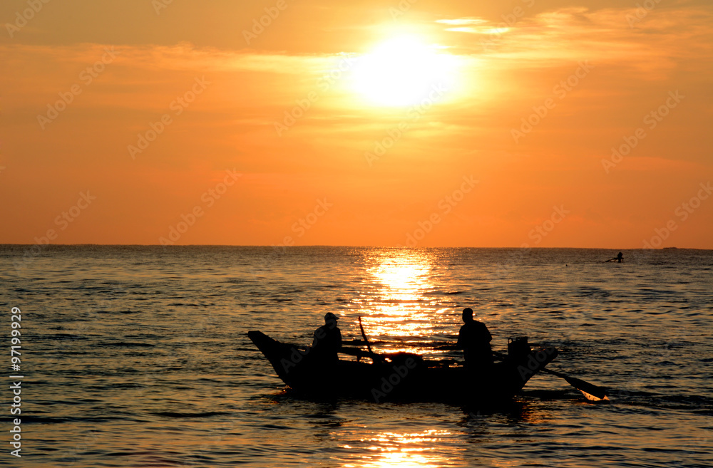 Wild beautiful beaches of Sri Lanka. Golden tropical sunset. Silhouette of  fishermen on the horizon.