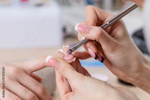 manicurist at work, painting nails in nail salon, UV lap of quic