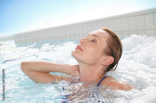 Beautiful woman relaxing in hot tub of spa center pool