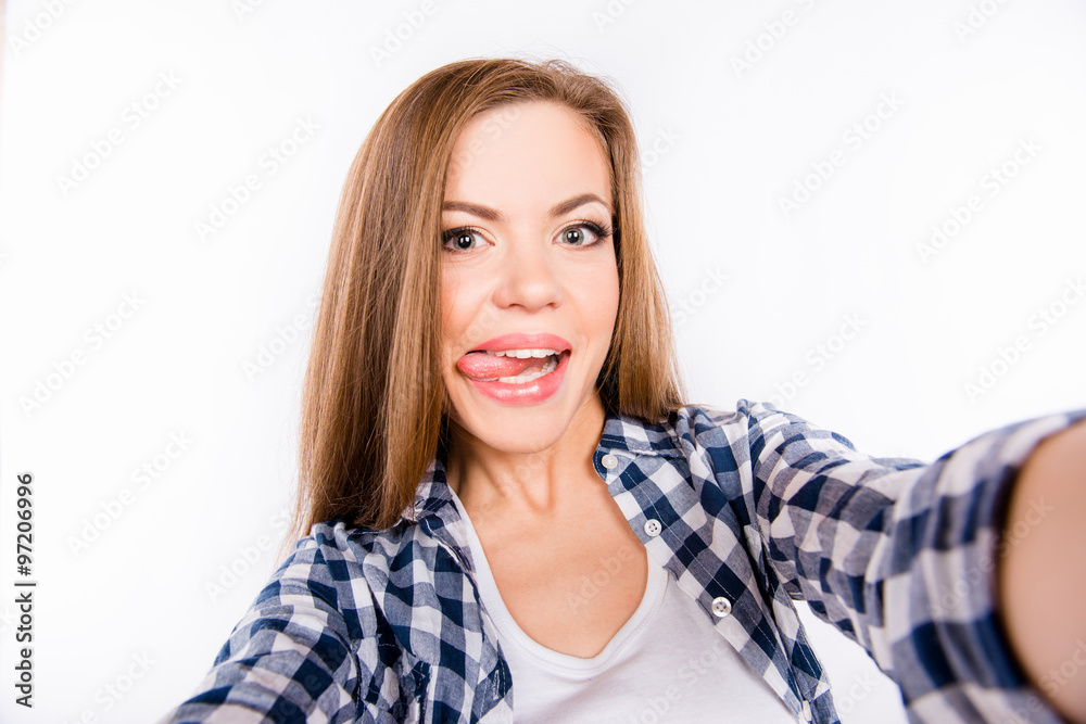 happy girl in a shirt making selfe photo and showing her tongue happy girl in a shirt making selfe photo and showing her tongue