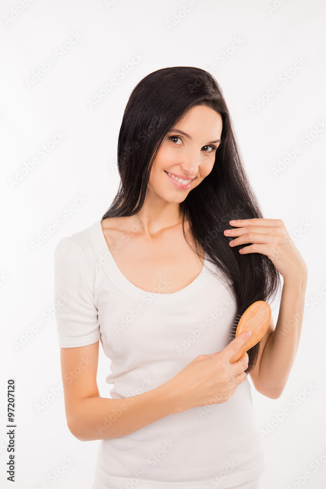 Cute happy girl combing her hair Cute happy girl combing her hair