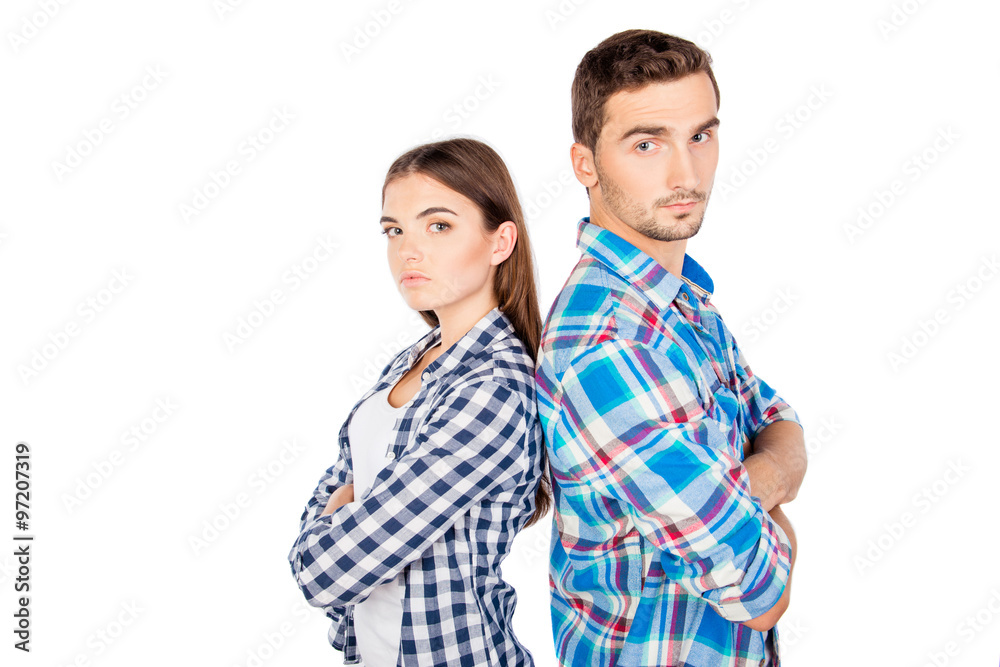 Young disconnected couple standing back to back Young disconnected couple standing back to back