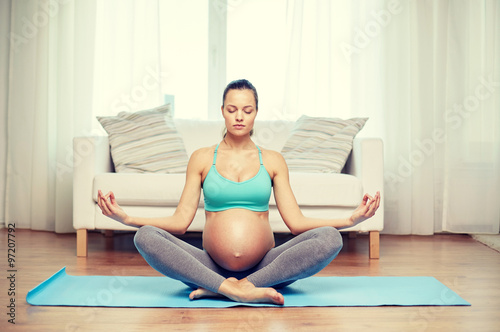 happy pregnant woman meditating at home