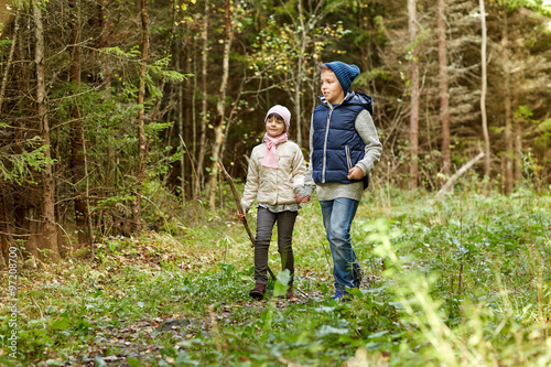 two happy kids walking along forest path