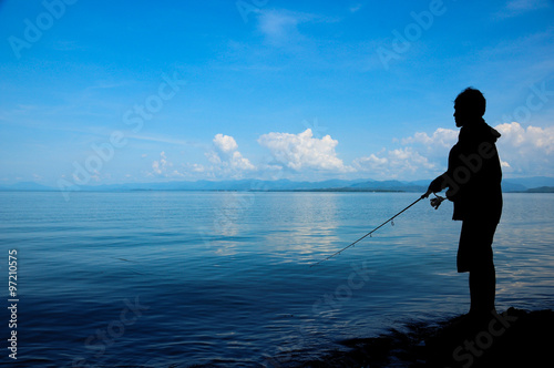 Silhouette fisherman on the shore