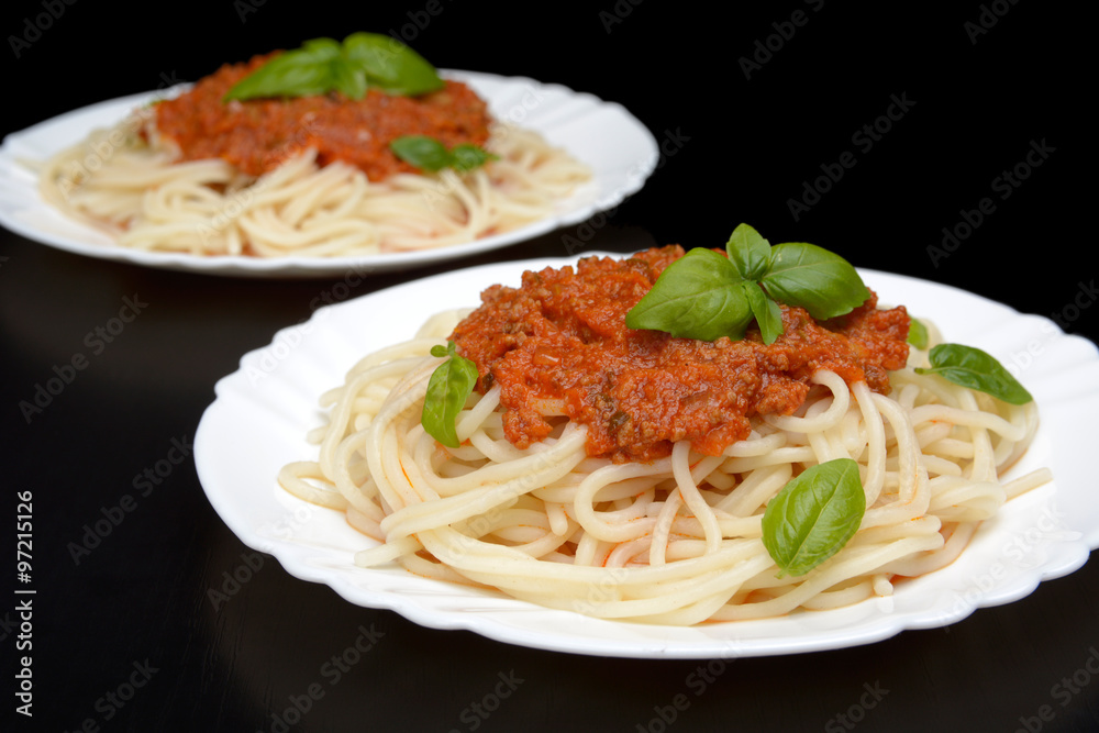 Two dish pasta with bolognese sauce on black Two dish pasta with bolognese sauce on black