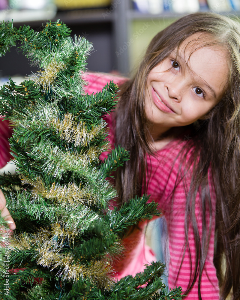 Little girl decorating Christmas tree Little girl decorating Christmas tree