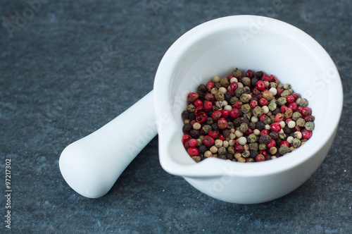 white china mortar with color pepper on stone background