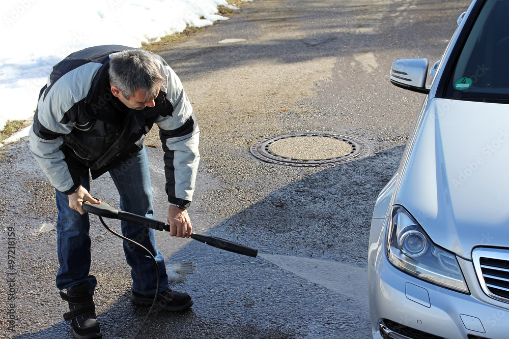 Autowäsche im Winter - Ein Mann wäscht im Winter sein Auto Autowäsche im Winter - Ein Mann wäscht im Winter sein Auto
