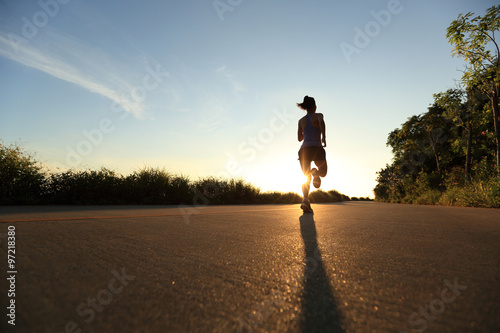 young fitness woman running on sunrise seaside trail