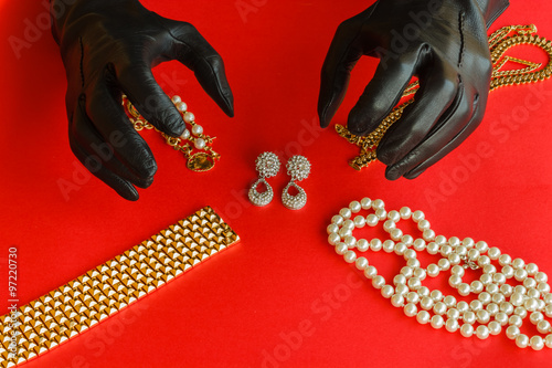 two hands wrapped in black gloves are going to steal the jewels