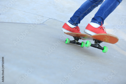 skateboarding legs riding on a skateboard © lzf
