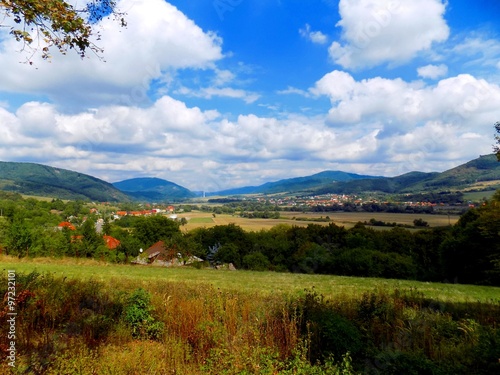 Meadow, forests, village and sky