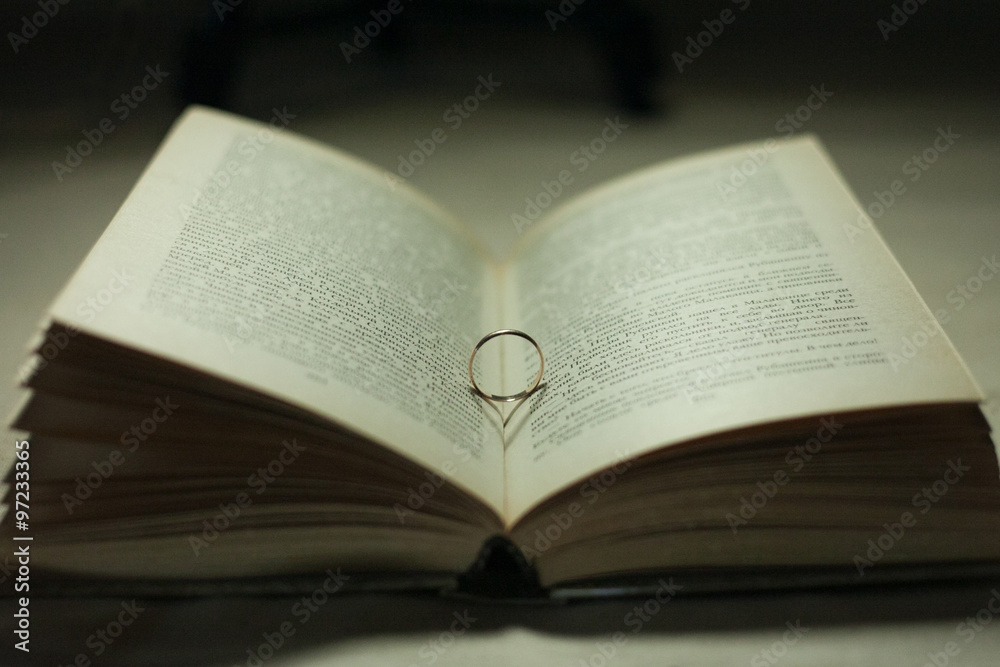 Wedding ring casting a heart onto a bible Wedding ring casting a heart onto a bible
