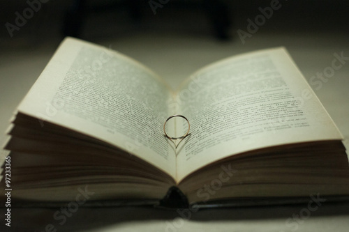 Wedding ring casting a heart onto a bible
