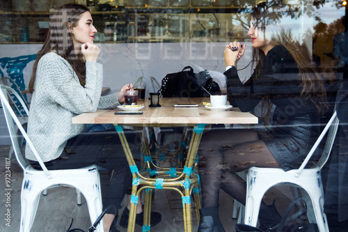 Beautiful young women drinking tea in a coffee shop.
