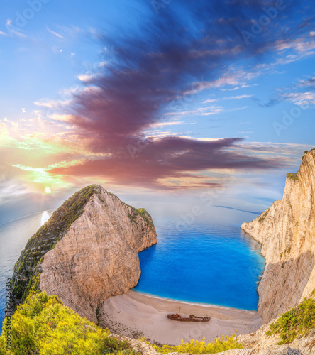 Navagio beach with shipwreck and flowers against sunset, Zakynthos island, Greece