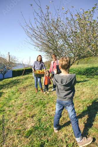 Boy taking photo to family with apples in basket