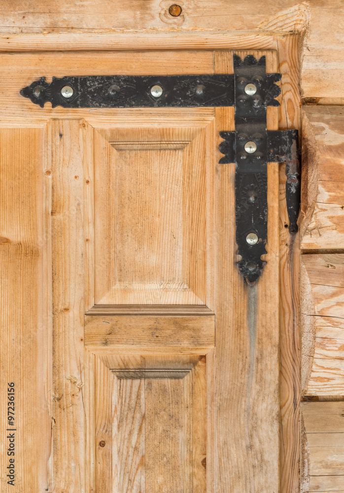 Close up of wooden door with black hinge