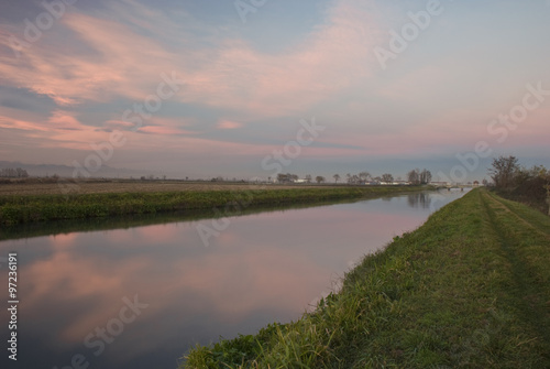 tramonto sulla pianura Vercellese ,con le nuvole riflesse sull'acqua del canale