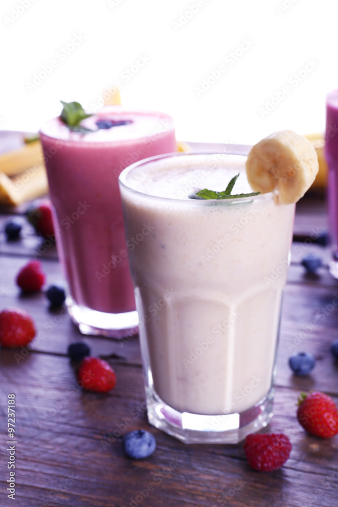 Glasses of fresh cold smoothie with fruit and berries, isolated on white Glasses of fresh cold smoothie with fruit and berries, isolated on white