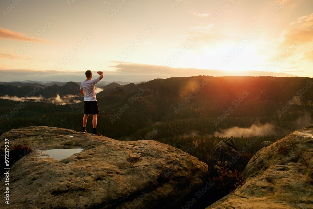 Obraz premium Runner man in his target with hand in the air. Sweaty man in black pants and white sweaty t-shirt,