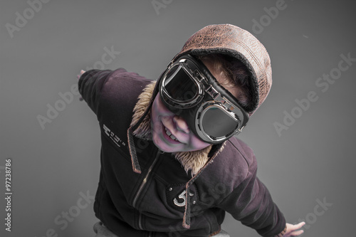 child playing the aircraft pilot with hat and retro bomber jacke
